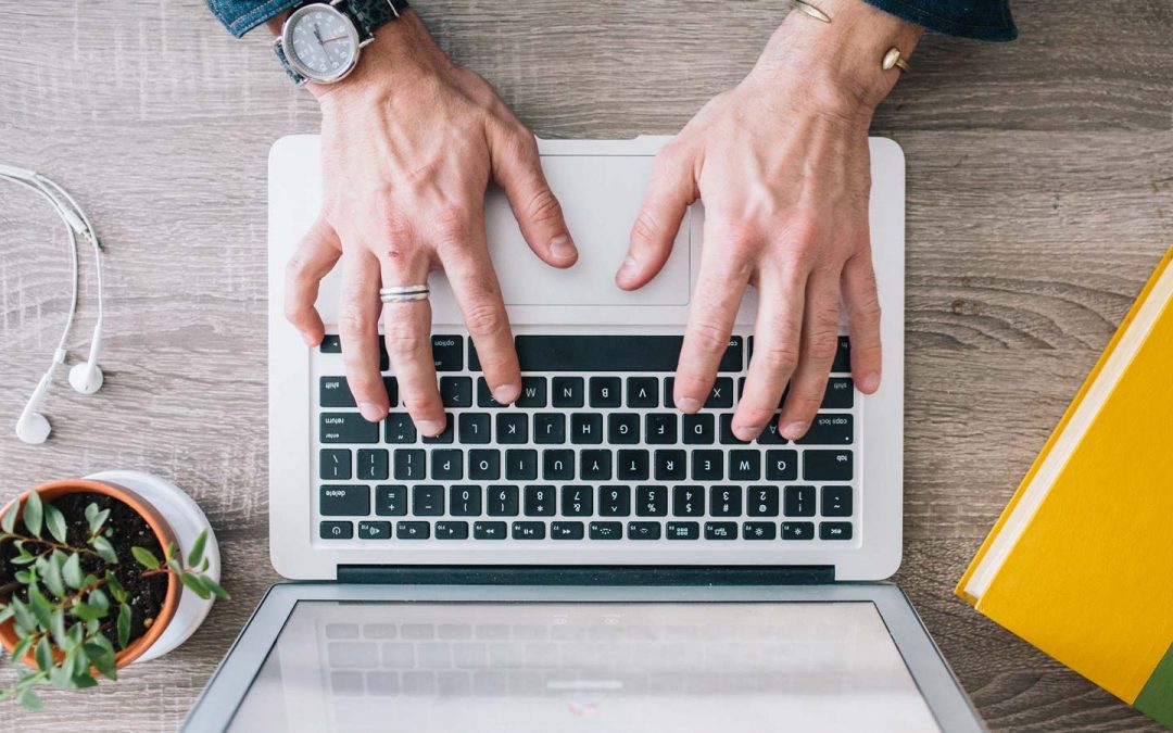 Mann tippt auf MacBook-Tastatur